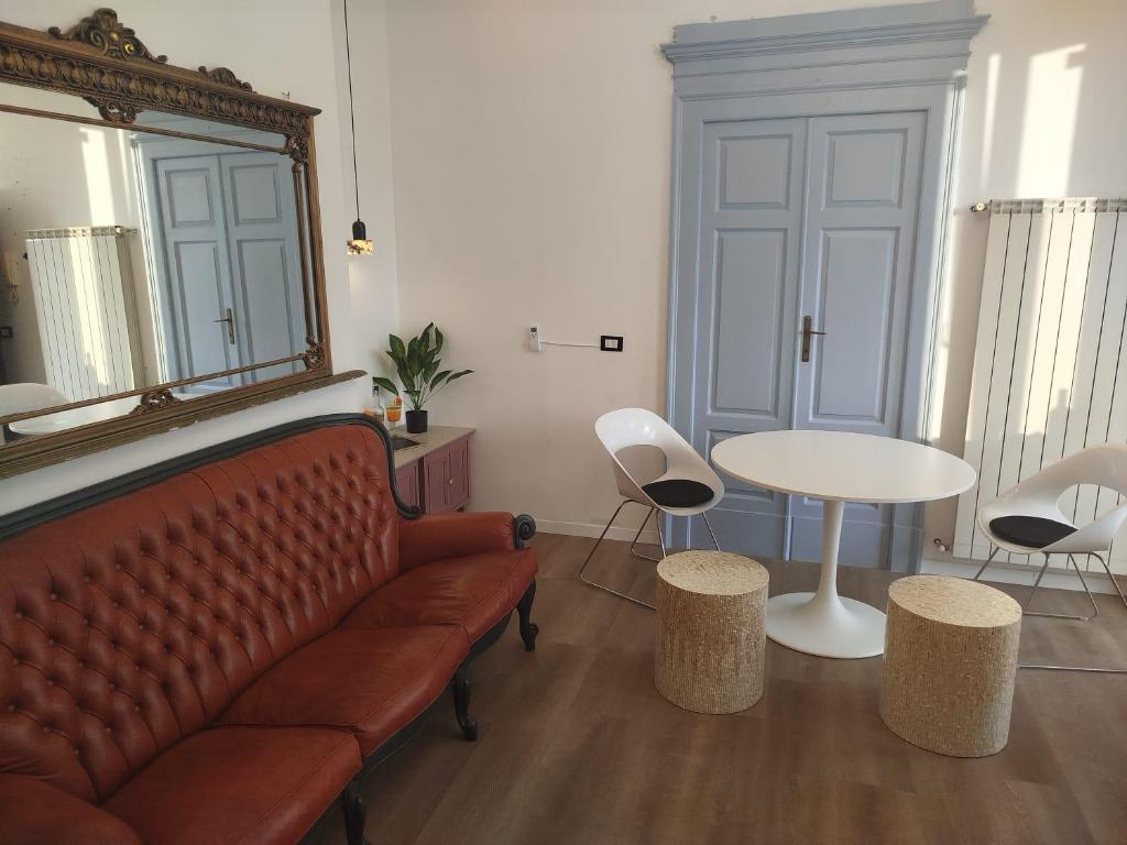 ein Wohnzimmer mit einer Couch und einem Tisch und Stühlen in der Unterkunft HERITAGE HOUSE City Center -ENTIRE APARTMENT- in Pescara