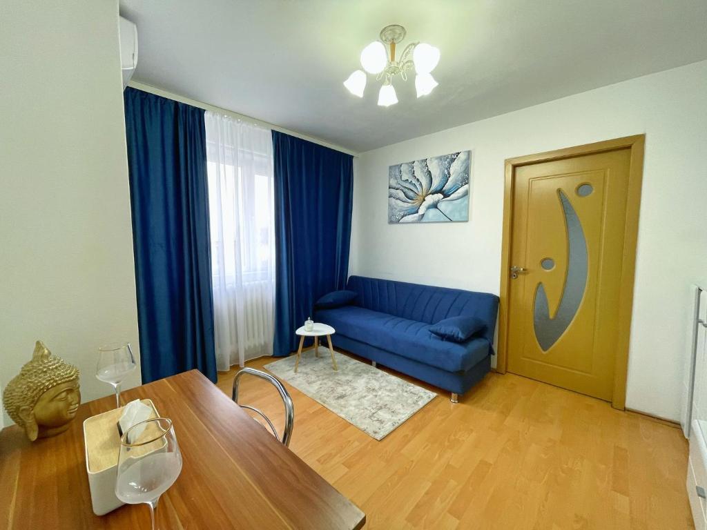a living room with a blue couch and a table at BDR Residence in Craiova