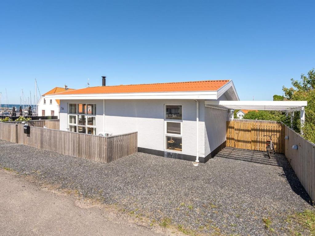 a white house with a fence in front of it at Holiday Home Ljubinko - 50m from the sea by Interhome in Læsø