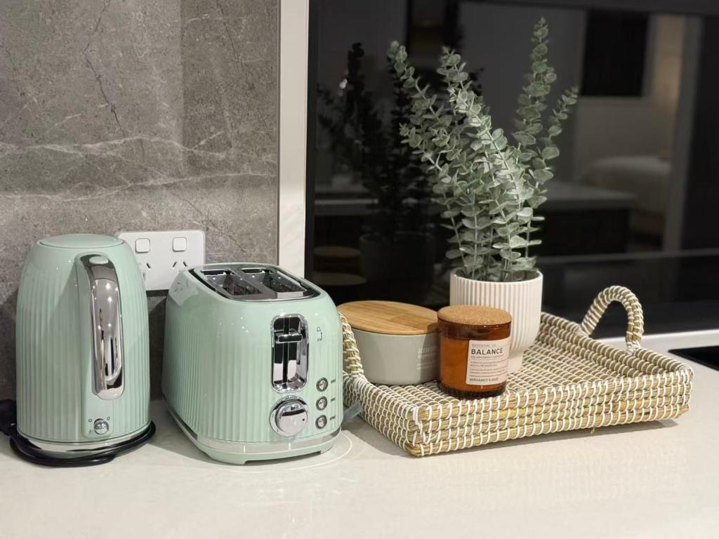 Ein Toaster und andere Gegenstände stehen auf einer Arbeitsfläche. in der Unterkunft Sunnybank Station 5B Family Stay in Brisbane