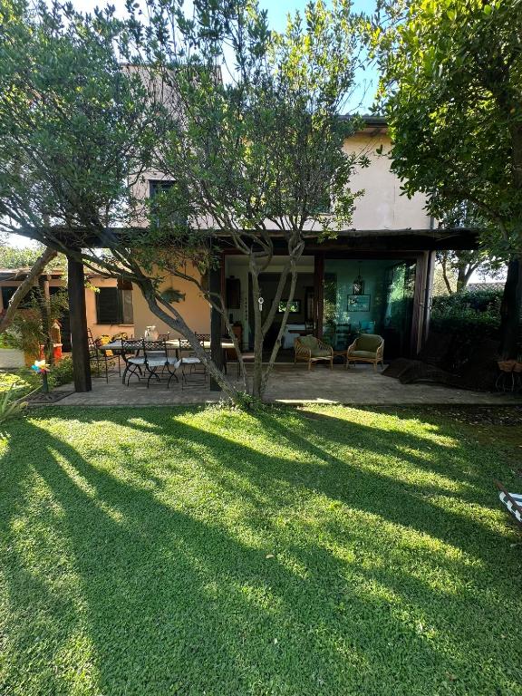 a house with a yard with a picnic table and trees at Villa a Capalbio in Carige Bassa