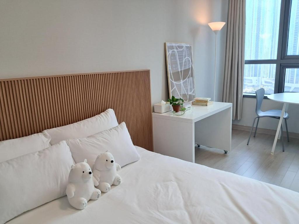 zwei ausgestopfte Tiere auf einem Bett in der Unterkunft Cozy Stay #Songdo Dalbit Festival Park in Incheon