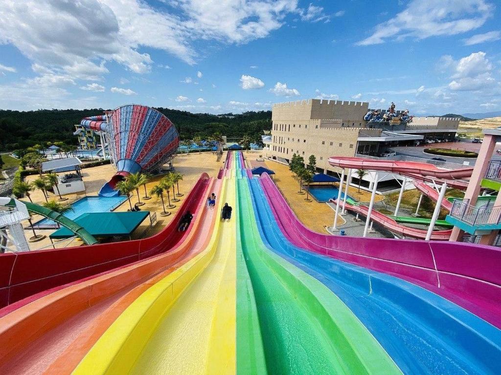 eine regenbogenfarbene Rutsche in einem Vergnügungspark mit Achterbahn in der Unterkunft Bangi Tiara Imperial Studio, 1, Jalan Ilmiah BANGI in Bangi