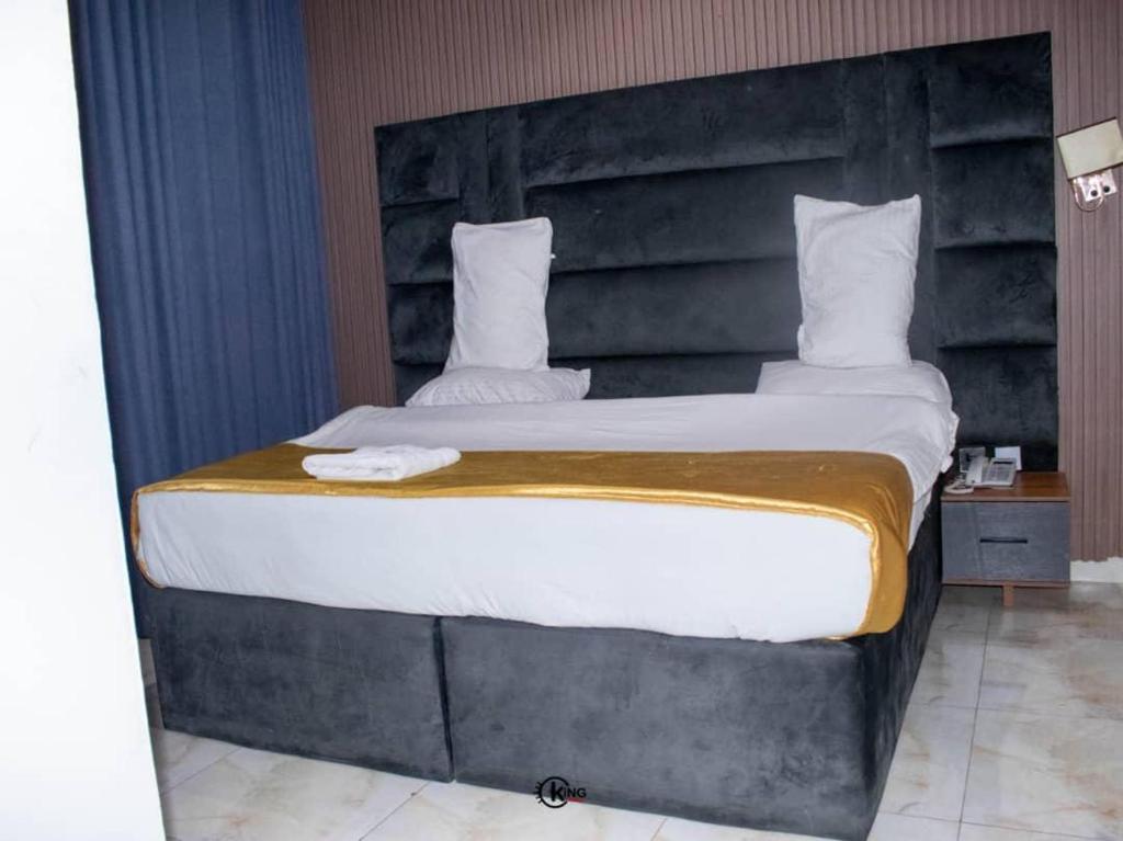 a large bed with a large headboard in a room at Royal Dean Hotels & Suites in Mama