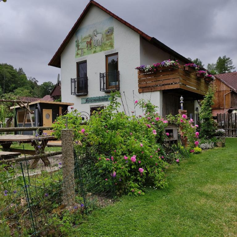 ein Haus mit Blumen davor in der Unterkunft Limerhof in Waischenfeld
