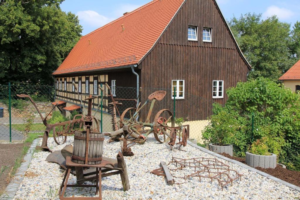 a barn with a bunch of rusty equipment in front of it at Wohnung Mit Terrasse Im Sanierten Fachwerkhof in Müglitztal