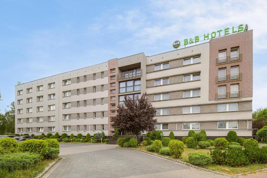 a large tan building with a sign on it at B&B HOTEL Bytom in Bytom