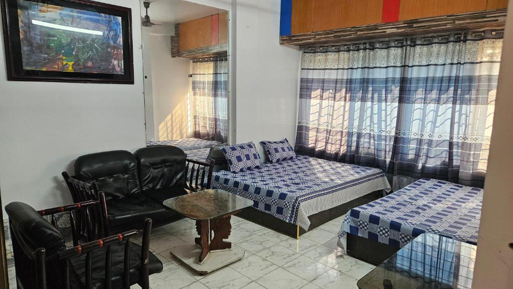 Una sala de estar con un sofá, una cama y una silla. en Sky Garden Home, en Dhaka