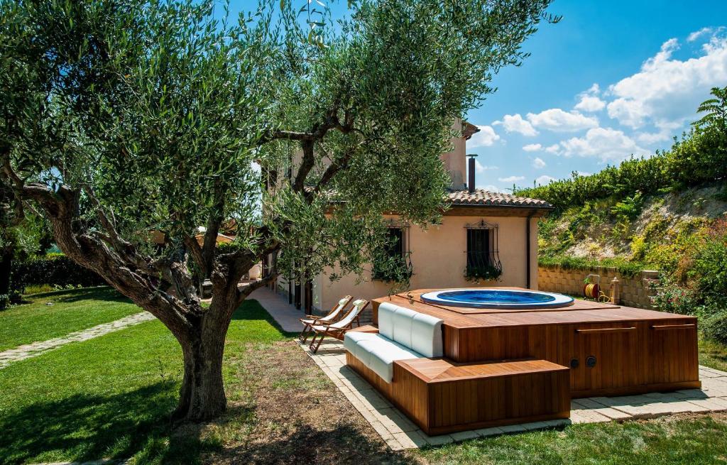 une cour arrière avec un jacuzzi et un arbre dans l'établissement Villa Mauro, à Mondolfo