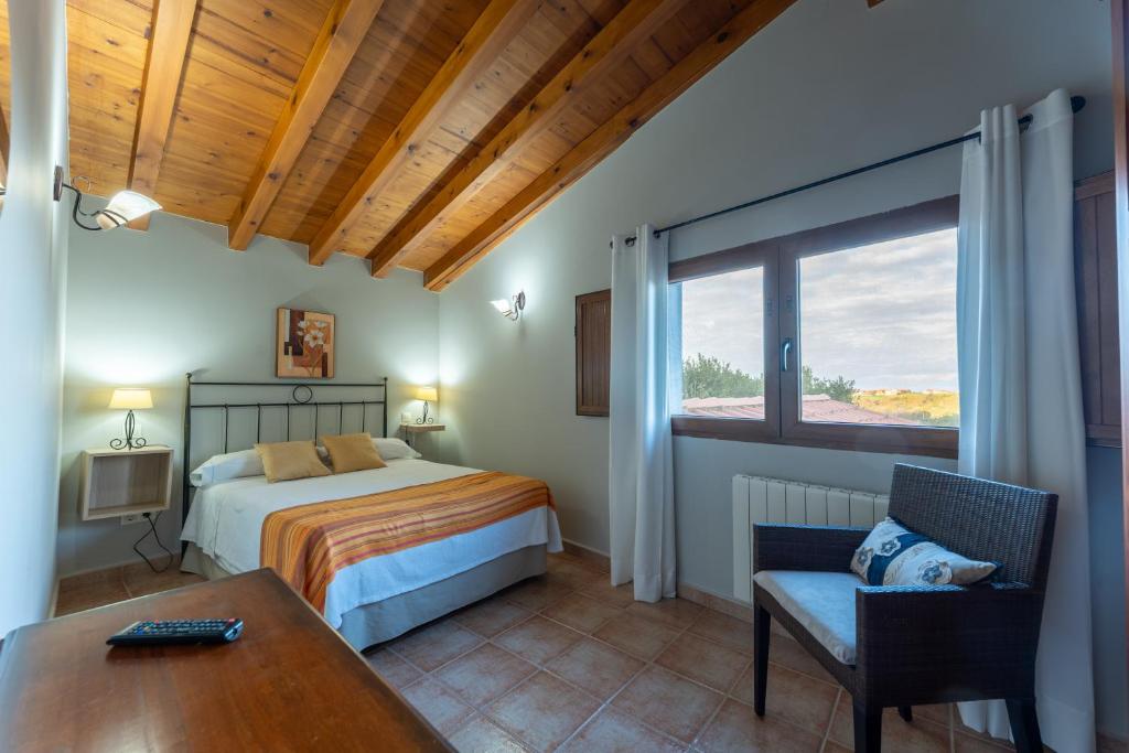 a bedroom with a bed and a table and a window at Posada La Canal in Ubiarco