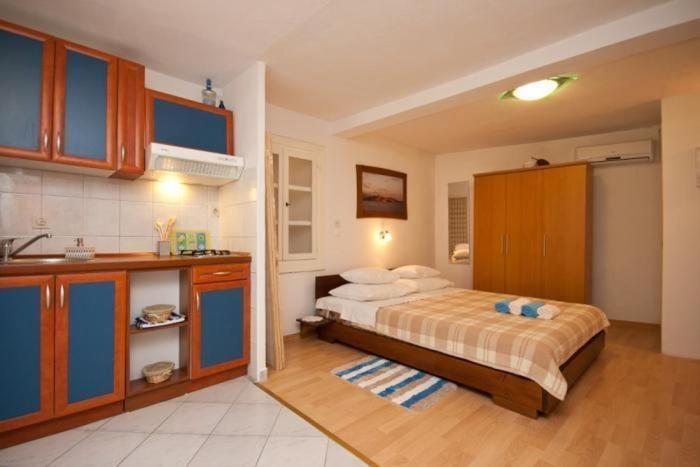 a large bedroom with a bed and a kitchen at Studio In Einem Traditionellen Steinhaus, In Baska in Baška
