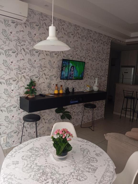 a living room with a table with a vase of flowers at Beira-mar in Santos