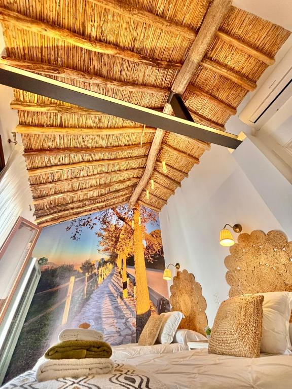 a room with a bed with a large window with a view at Recuerdos del Sur in El Gastor