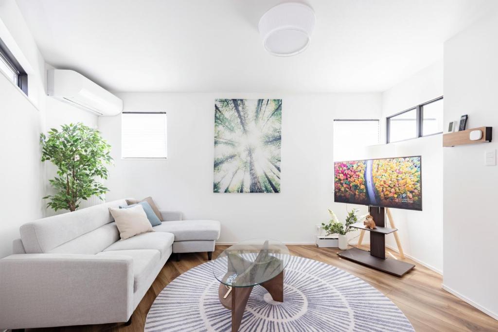 ein weißes Wohnzimmer mit einer Couch und einem Tisch in der Unterkunft First Choice in Tokio