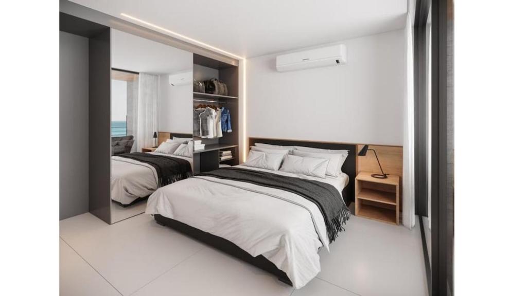 a bedroom with two beds and a mirror at Muro Alto em Porto de Galinhas Apto Alto Padrão in Ipojuca