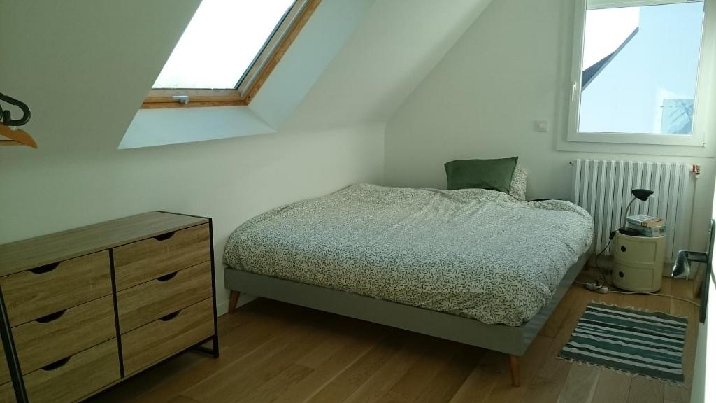 ein Schlafzimmer mit einem Bett, einer Kommode und zwei Fenstern in der Unterkunft Chambre chez l'habitant in Crach