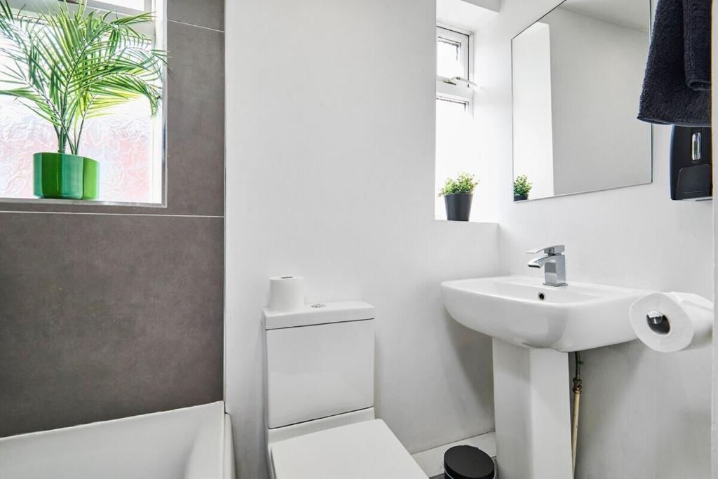 a white bathroom with a sink and a mirror at Stylish Studio Apt in Leeds in Headingley