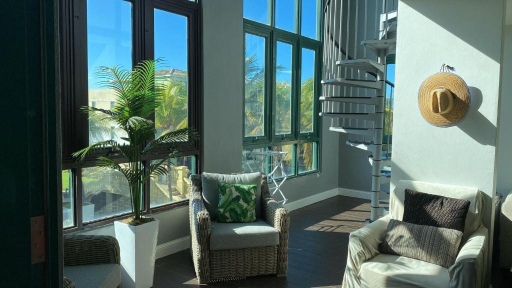 ein Wohnzimmer mit 2 Stühlen und einer Pflanze in der Unterkunft Aquatika 3 Bed 2 Bath 2 Par in Vieques