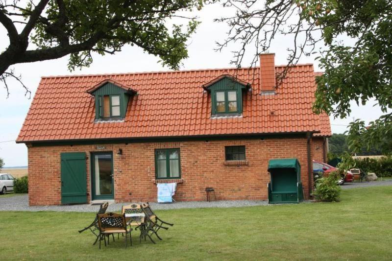 a brick house with a table and chairs in front of it at Ferienhaus Kranich In Ummanz Lüßvitz in Ummanz