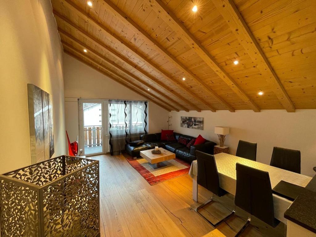 采尔马特Penthouse Matterhorn Vista的客厅里有一张桌子和一张沙发