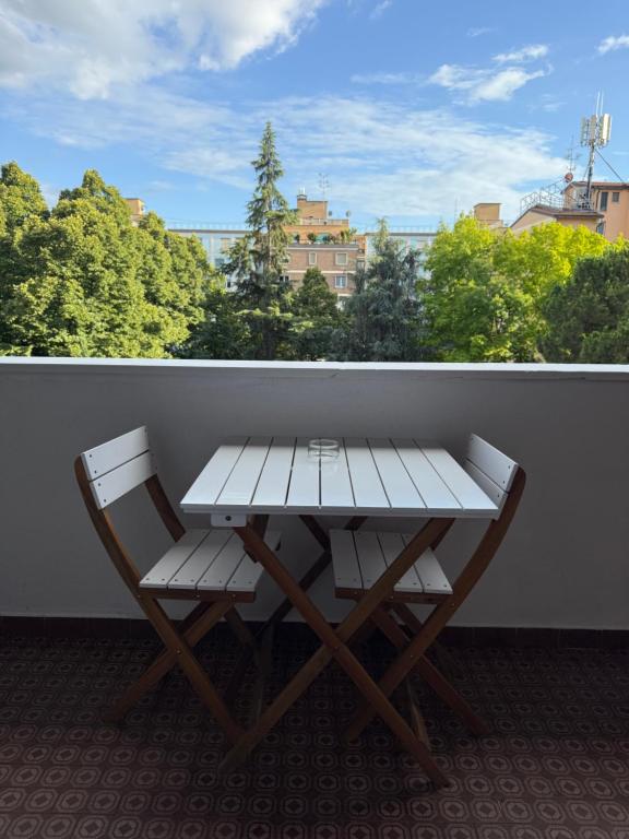 博洛尼亚Alam B&B Bologna的阳台上配有野餐桌和两把椅子