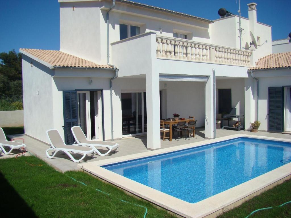 eine Villa mit einem Swimmingpool vor einem Haus in der Unterkunft Helles und modern eingerichtetes Ferienhaus mit eigenem Pool und sonniger Terrasse in Cala Bona