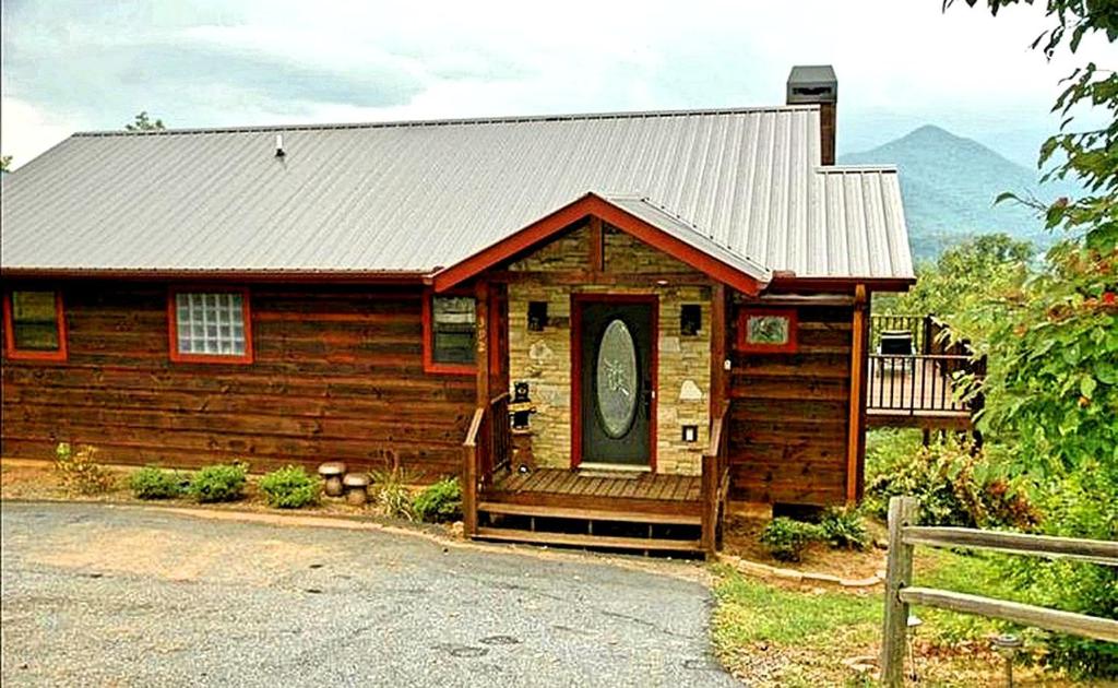 Cette petite cabane en bois dispose d'une véranda et d'une porte. dans l'établissement Breathtaking Cabin Rental with a Private Hot Tub in Hiawassee, Georgia, à Hiawassee