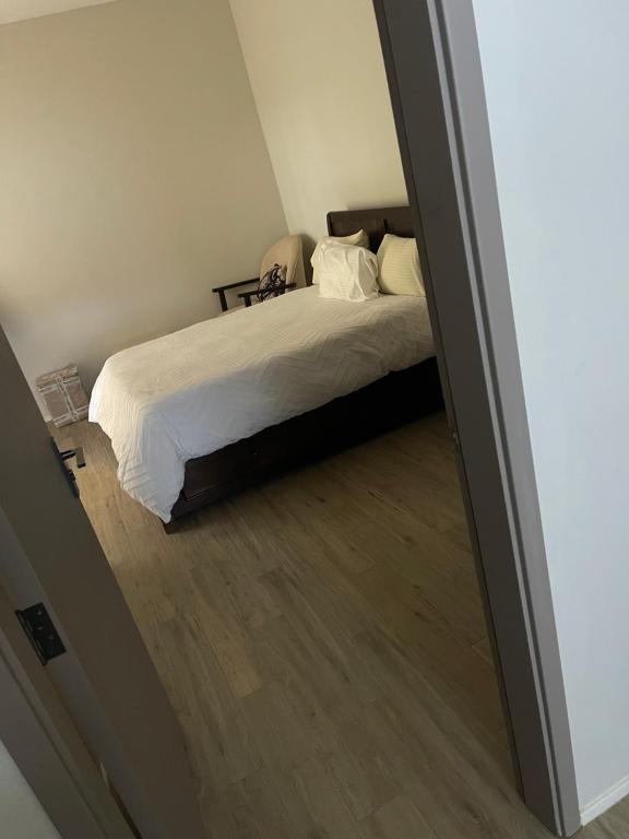 een bed met witte lakens en kussens in een slaapkamer bij NK Plaza in Nairobi