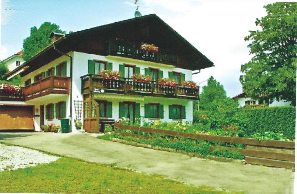 ein Haus mit Blumenkästen auf den Balkonen in der Unterkunft Dachgeschosswohnung mit toller Aussicht vom Balkon auf den wenige Meter entfernten See in Bayersoien