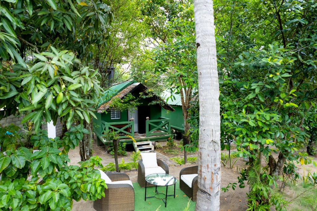 a group of chairs and a house in the forest at Le Jardin Arhumatic Sambava in Sambava