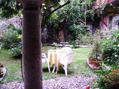 einen Tisch und Stühle in einem Garten mit Tisch und Stühlen in der Unterkunft Ferienwohnung für 5 Personen ca 50 m in Miasino, Piemont Ortasee in Miasino