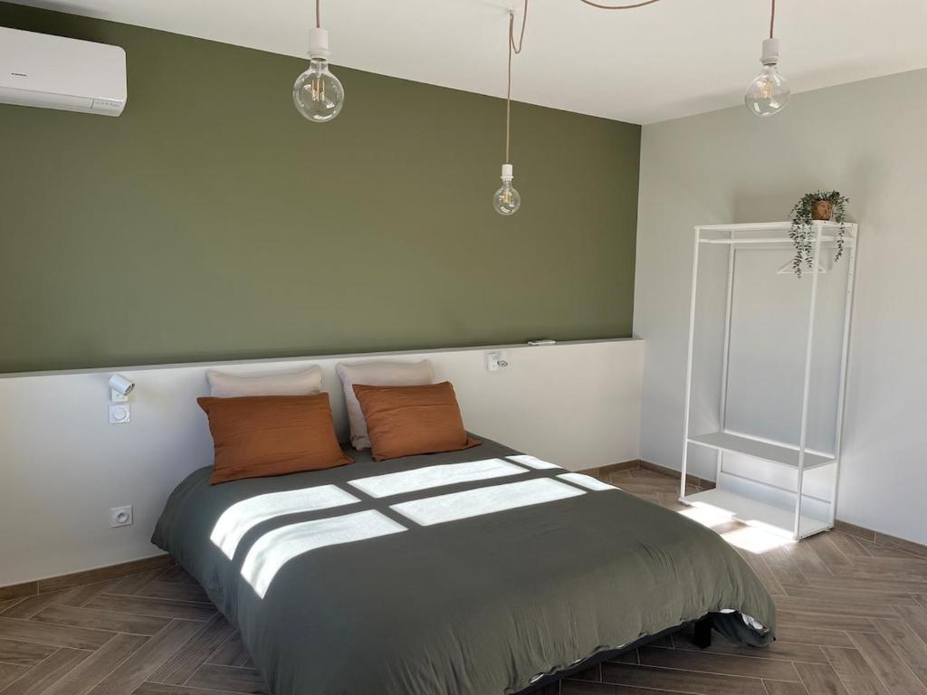 Chez Louise et Léo في إج مورت: غرفة نوم مع سرير كبير مع وسائد برتقالية