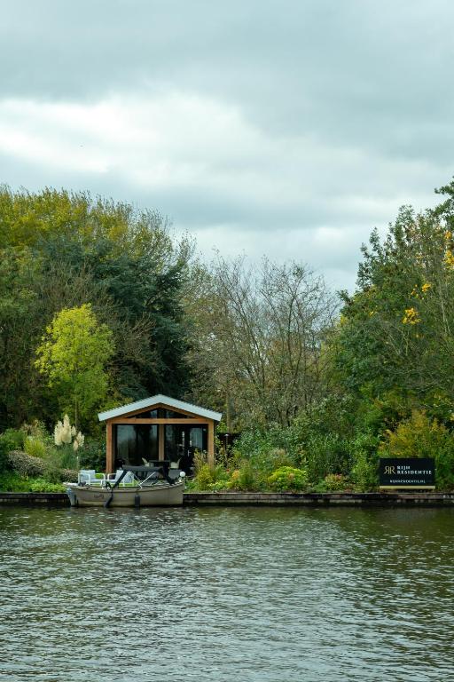 a small boat parked on the side of a lake at Rijn Residentie in Alphen aan den Rijn