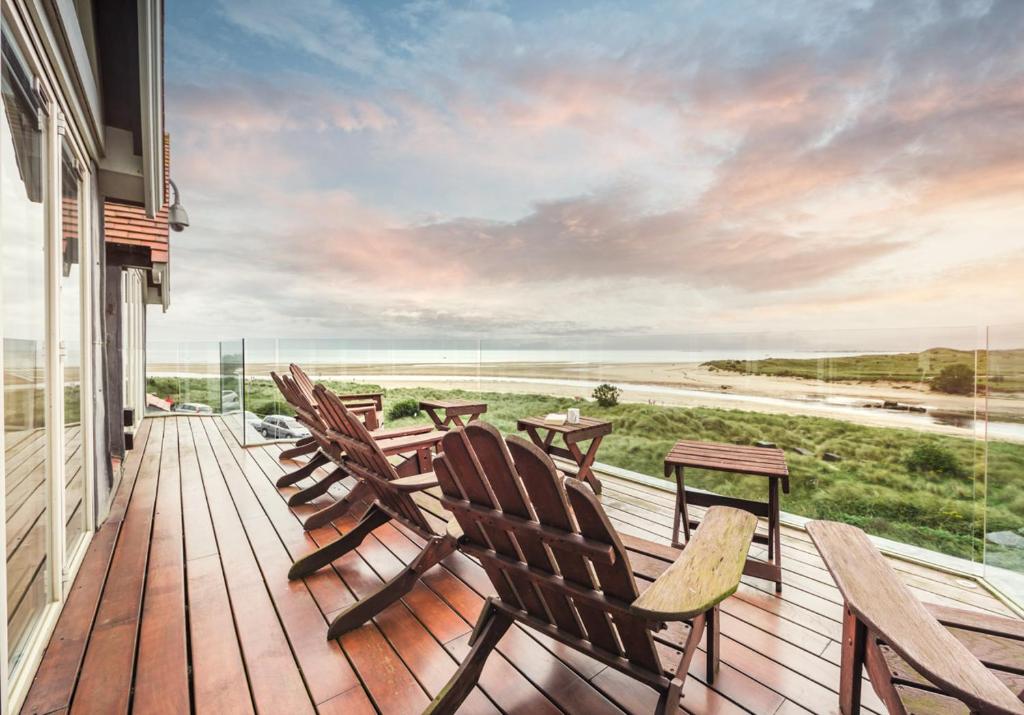 a deck with chairs and a table and a view of the ocean at Seaview Penthouse 2 in Alnmouth