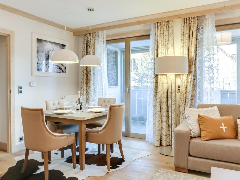 une salle à manger avec une table, des chaises et un canapé dans l'établissement Appartement moderne avec WiFi et parking sous-terrain à Courchevel Village - FR-1-562-28, à Courchevel