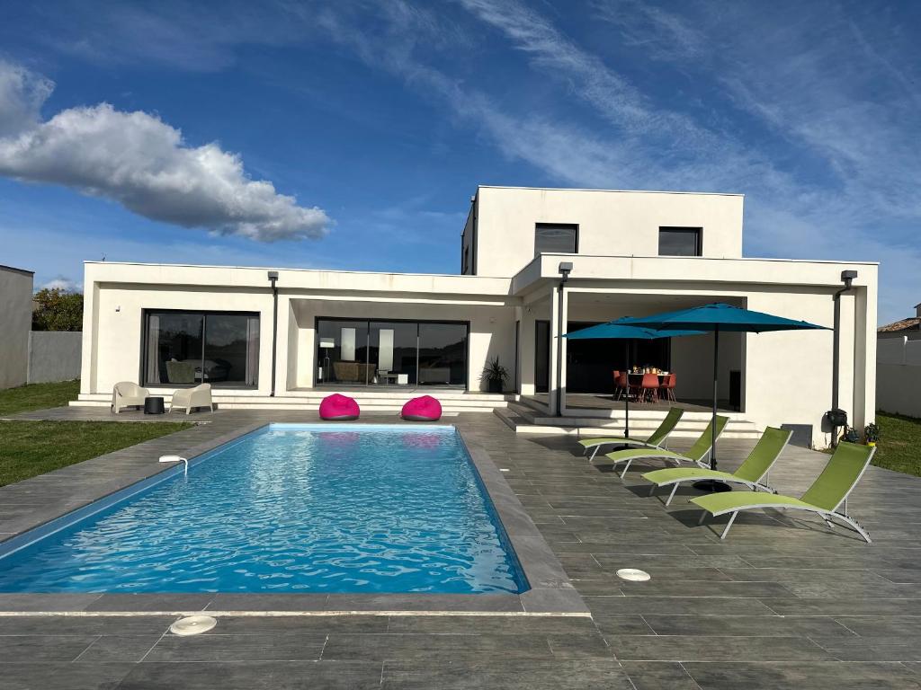 a house with a swimming pool and some chairs at Spacieuse villa standing de 220m2 in Aléria