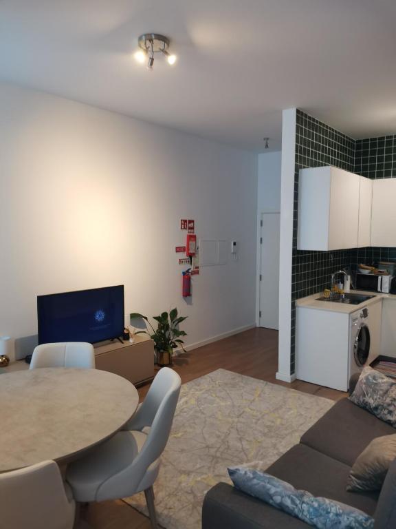 a living room with a table and a kitchen at Casa da Lara in Aveiro