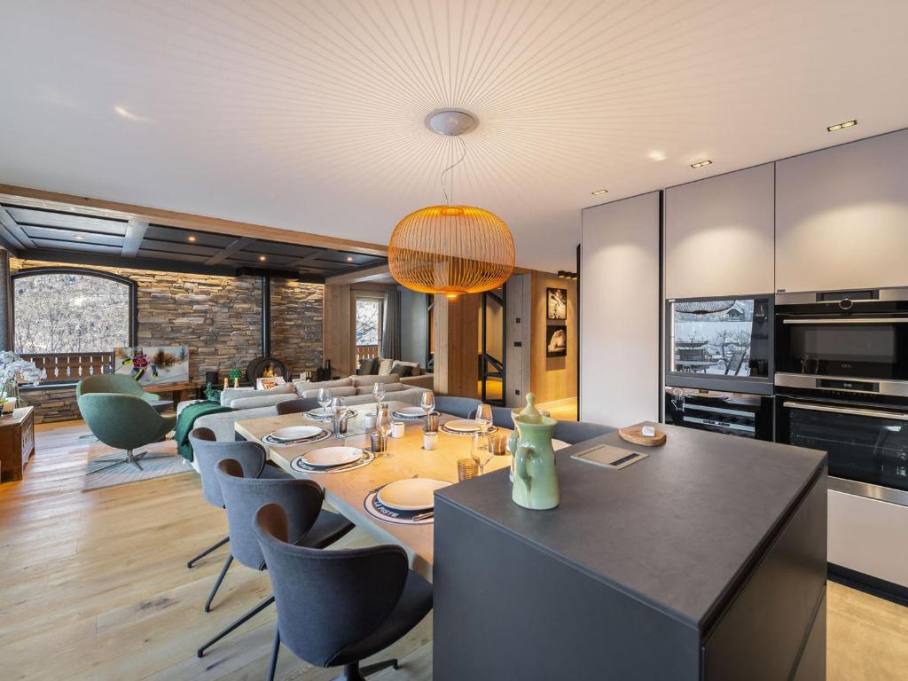 une salle à manger avec une longue table et des chaises dans l'établissement Chalet familial moderne à Méribel Village, terrasse sud avec jacuzzi, proche pistes et commerces - FR-1-566-56, à Les Allues