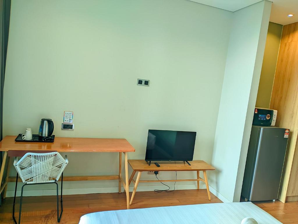 a room with a desk with a television and a table at Sky Suite KLCC Apartment klcc in Gua Sai