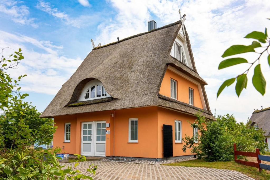 an orange house with a thatched roof at Ferienhaus Jaguar in Gramkow