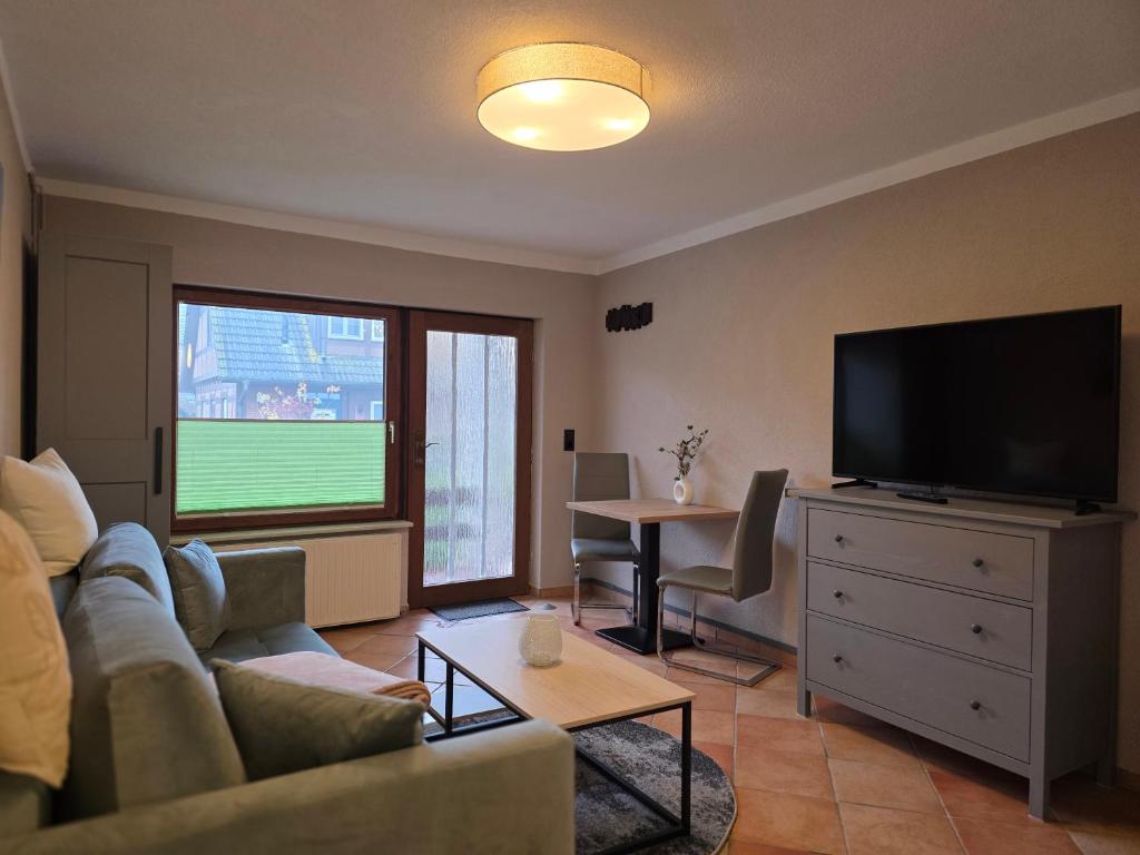 Una sala de estar con un sofá y un televisor de pantalla plana. en Appartment Zweierlei, en Zingst