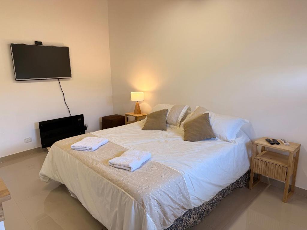 a bedroom with a bed with two towels on it at Cocheras Ezeiza Victoria in Ezeiza