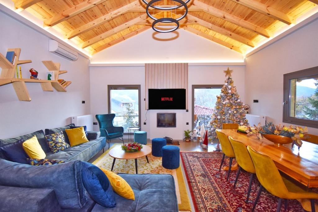 ein Wohnzimmer mit einem Sofa, einem Tisch und einem Weihnachtsbaum in der Unterkunft Villa Sokratis Mountain View in Porti 
