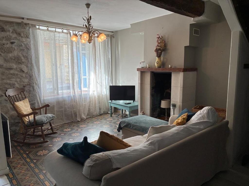 a living room with a couch and a fireplace at Spacious Village House in Ginoles with Garden in Ginoles