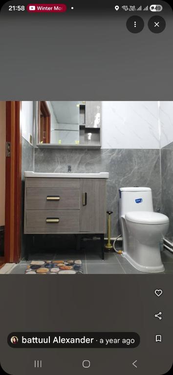 a bathroom with a white toilet and a sink at Bee Happy Hostel & Gobi amazing tour in Dalandzadgad