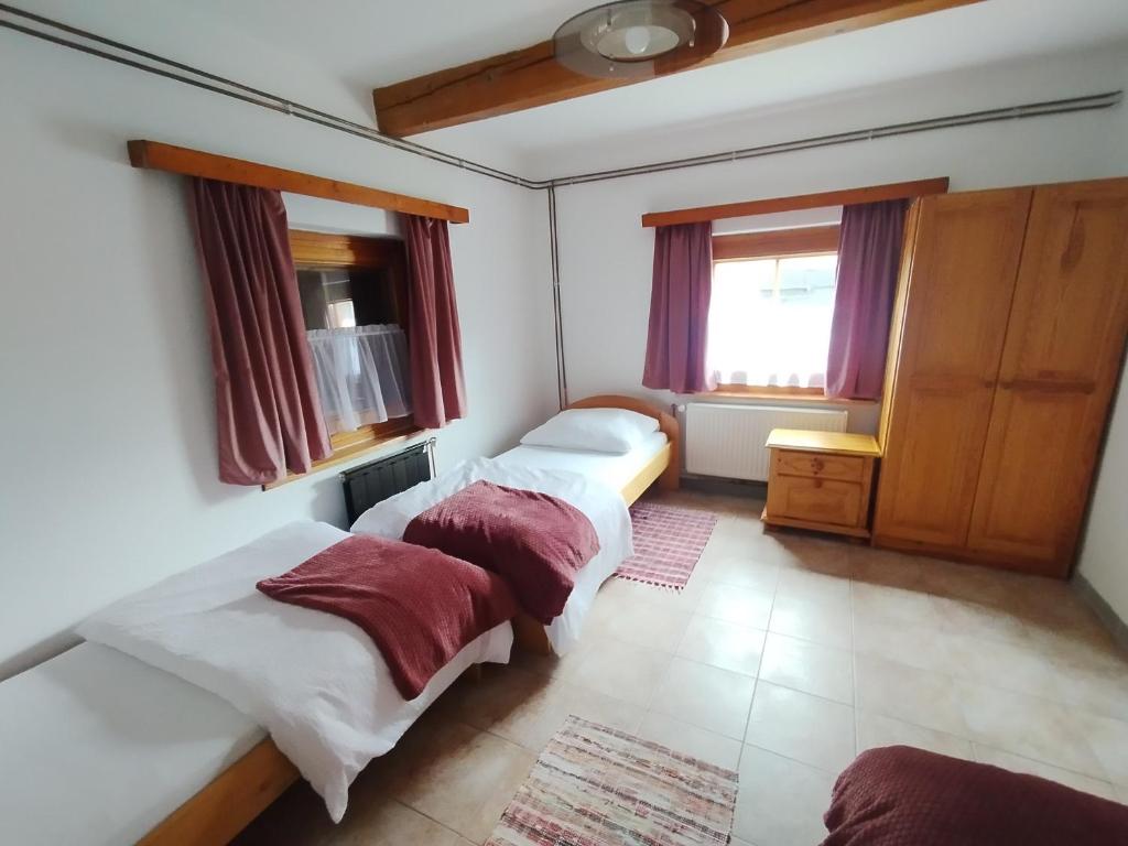 Un dormitorio con tres camas y una ventana. en Drevenica u Holtana mini, en Oščadnica
