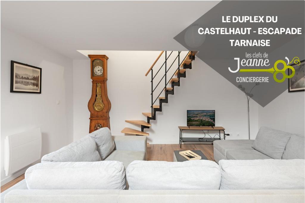 ein Wohnzimmer mit 2 Sofas und einer Uhr in der Unterkunft Le Duplex du Castel haut - Escapade Tarnaise in Castelnau-de-Montmiral