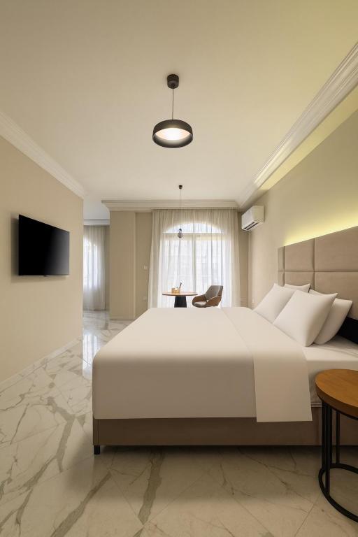 a bedroom with a large white bed and a table at 利恩之家 埃及会展中心 in Cairo