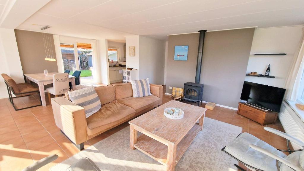 a living room with a couch and a fireplace at Hello Zeeland - Oosterpark 14 in Oostkapelle