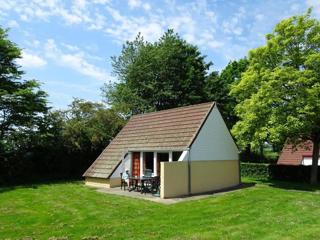 a small shed with a table in a yard at Bungalowpark Simpelveld - Alpha 97 in Simpelveld